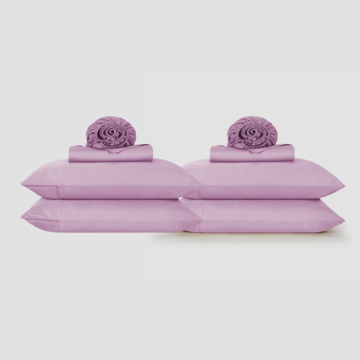 Lavender purple top sheets displayed flat with matching pillowcases and decorative rolled elements on neutral background