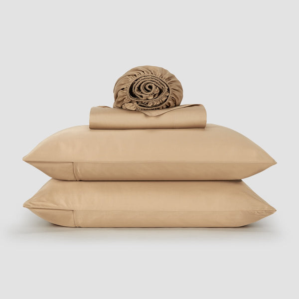 Woman in bed with pink bamboo sheets and pillows – soft, breathable and sustainable bedding
