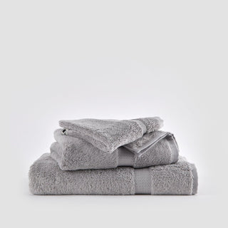 Gray bamboo towel set stacked against white background, including face, hand, and bath towels