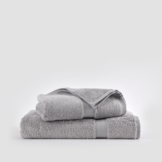 Gray bamboo towel set stacked on white background showing face, hand, and bath towels