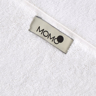 MOMO cotton brand label on white bamboo towel fabric close-up detail view