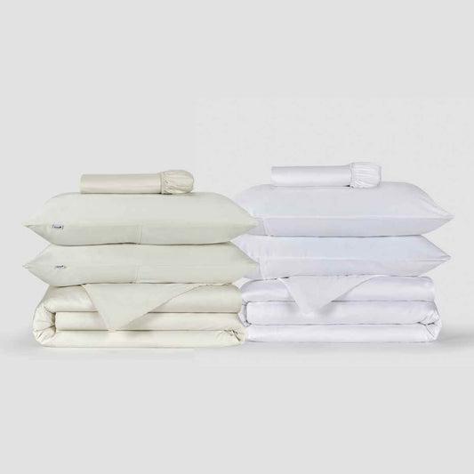 Cream and white bedding sets displayed with folded duvet covers, pillows, and sheets on white background