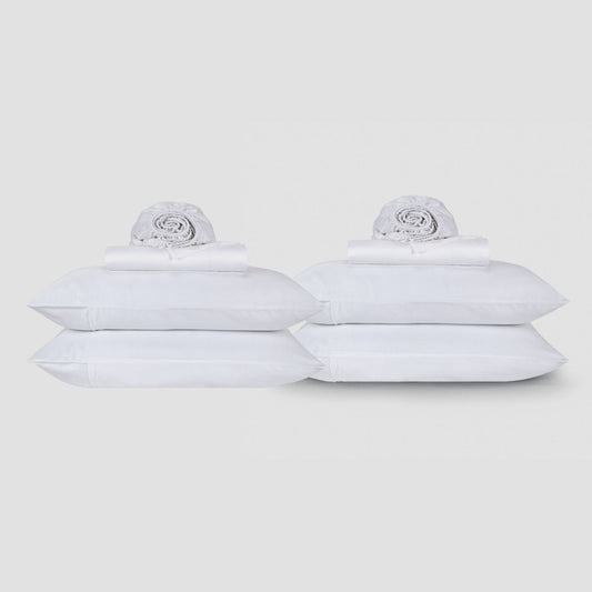 Two white cotton top sheets stacked with rolled linens displayed against neutral background by Momo Cotton
