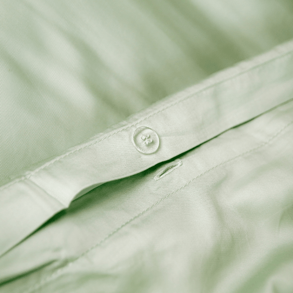 Green bamboo duvet cover with hidden button closure detail on fabric surface